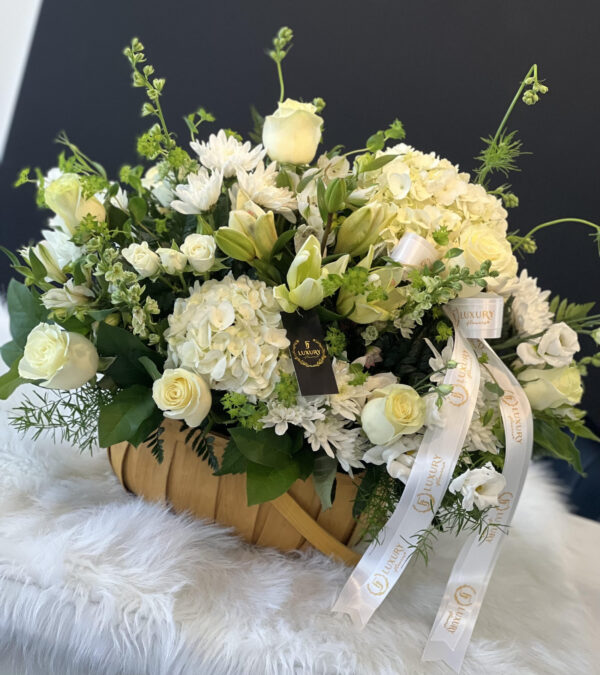 The White Sympathy Basket features fresh white flowers, thoughtfully selected based on availability, symbolizing peace and remembrance