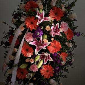 Oval Colorful Standing Spray with vibrant flowers, selected based on store availability. A heartfelt tribute expressing love, remembrance, and comfort.