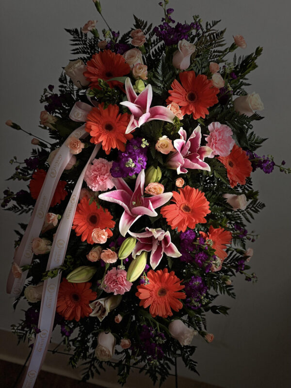 Oval Colorful Standing Spray with vibrant flowers, selected based on store availability. A heartfelt tribute expressing love, remembrance, and comfort.